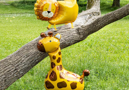 Laufende Airwalker Ballons Löwe und Giraffe an einem Baumstamm auf einer grünen Wiese
